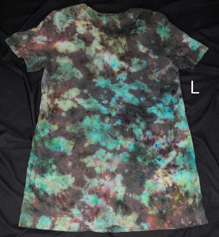 A short-sleeve tie-dye dress laid flat on a black fabric background, featuring a mottled pattern of teal, green, brown, and black. A white letter 'L' is shown to the right of the shirt.
