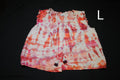 A sleeveless tie-dye top with ruffled shoulders and a drawstring front, shown laid flat on a black background. The fabric features a white base with orange, pink, and red tie-dye patterns.