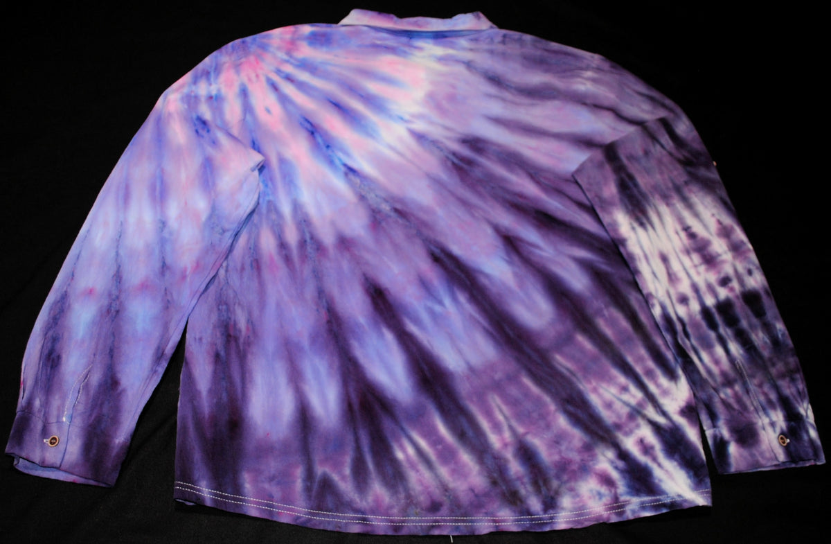 A long-sleeve tie-dye shirt shown from the back, featuring a vibrant purple, pink, and blue burst pattern on a black background.