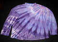 A long-sleeve button-up shirt with a purple, pink, and white tie-dye pattern, laid flat on a black background.